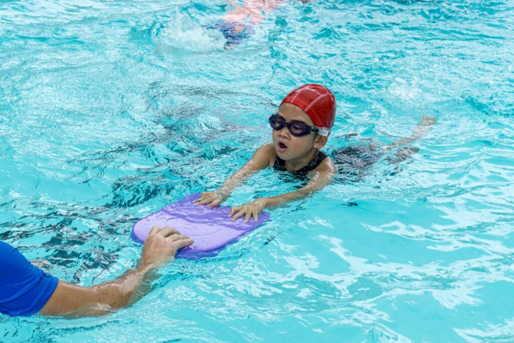 A kid is training hard in his private swimming lessons here at miami gardens